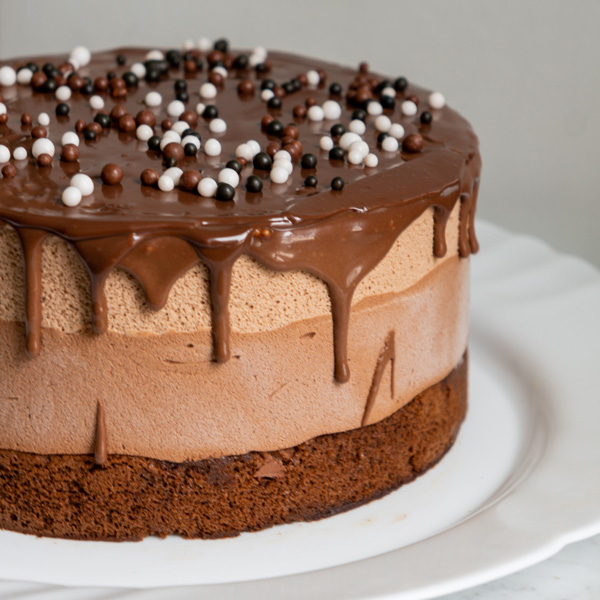 chocolate cake with chocolate drip frosting on white plate